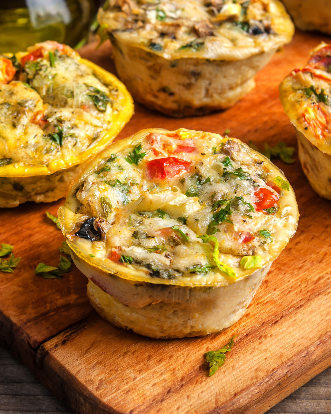 Egg muffins with vegetables and herbs on a wooden board