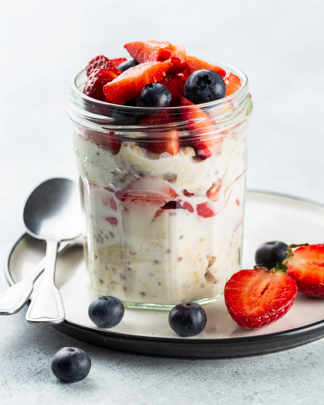 Jar of overnight oats topped with strawberries and blueberries